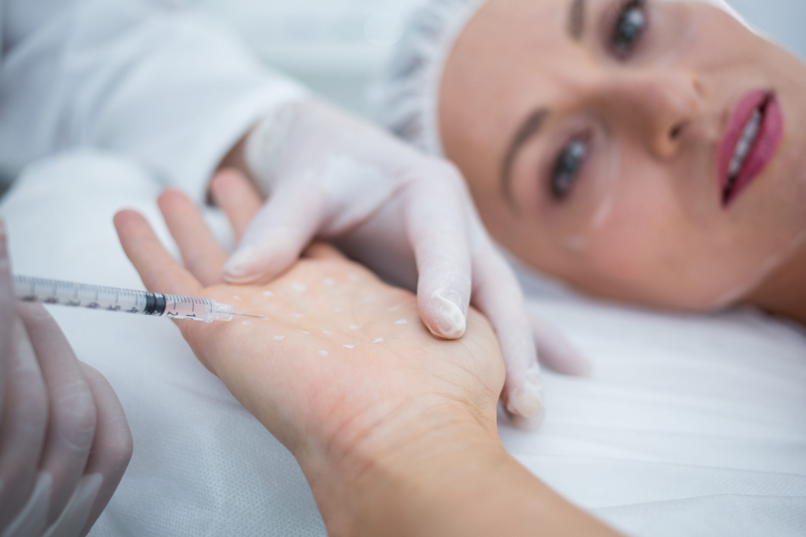 Close-up of doctor injecting woman on her palm